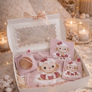 Coffret naissance bébé présenté dans une ambiance cocooning avec bavoir et lingettes assorties motif mouton, idée cadeau naissance, création artisanale Créatiph'n.